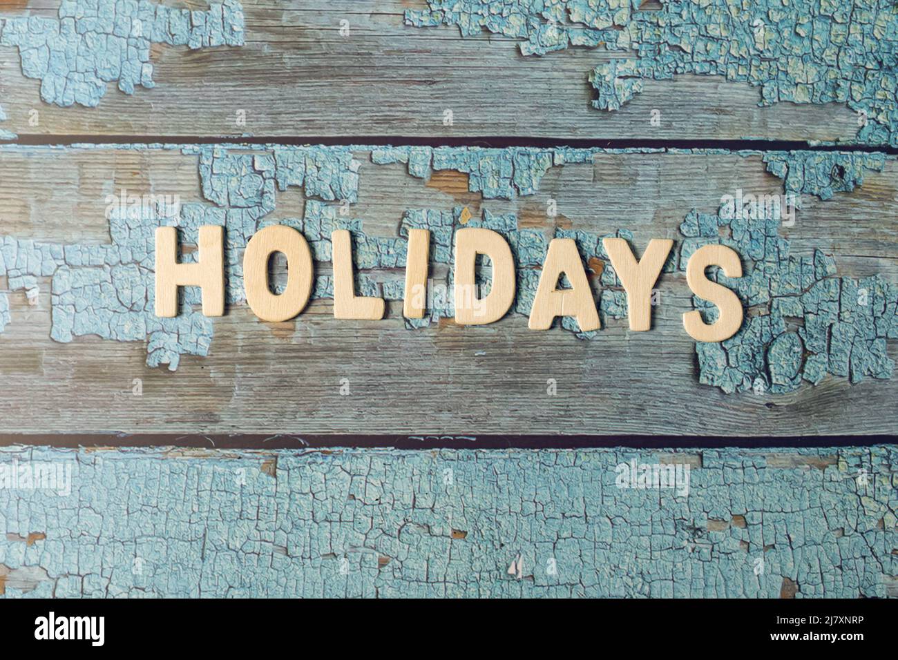 Holidays text word written on wooden letters on a textured blue wooden board Stock Photo