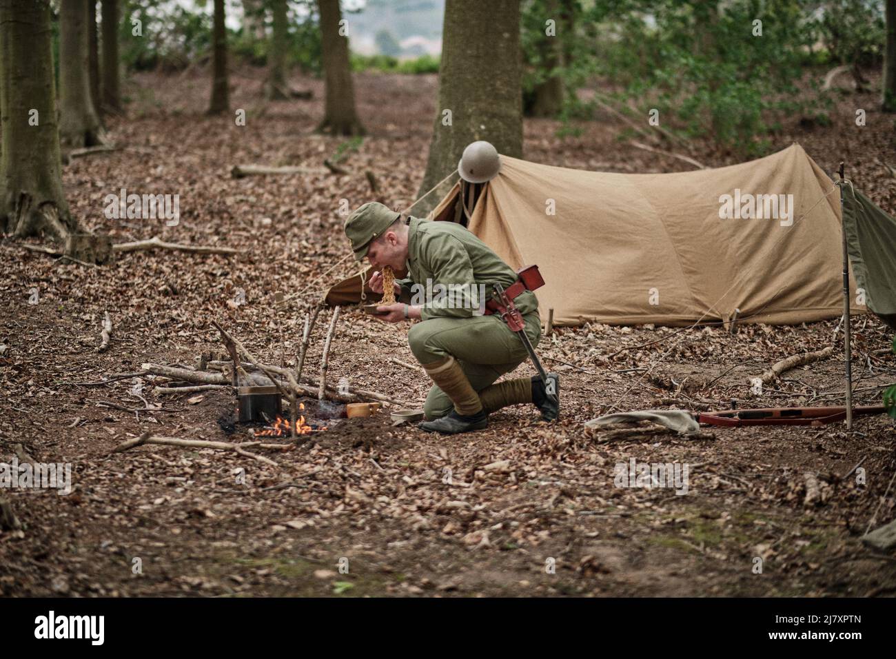 A Japanese soldier eats noodles in his camp in the woods at the No Man's Land Event at Bodrhyddan Hall, Wales Stock Photo