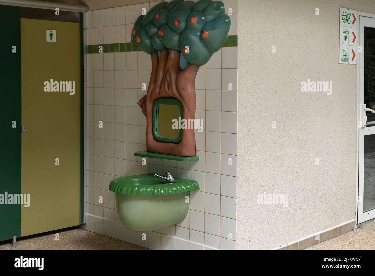 Hand washing sink for children moulded in plastic to look like a tree with a low mirror so they can see Stock Photo