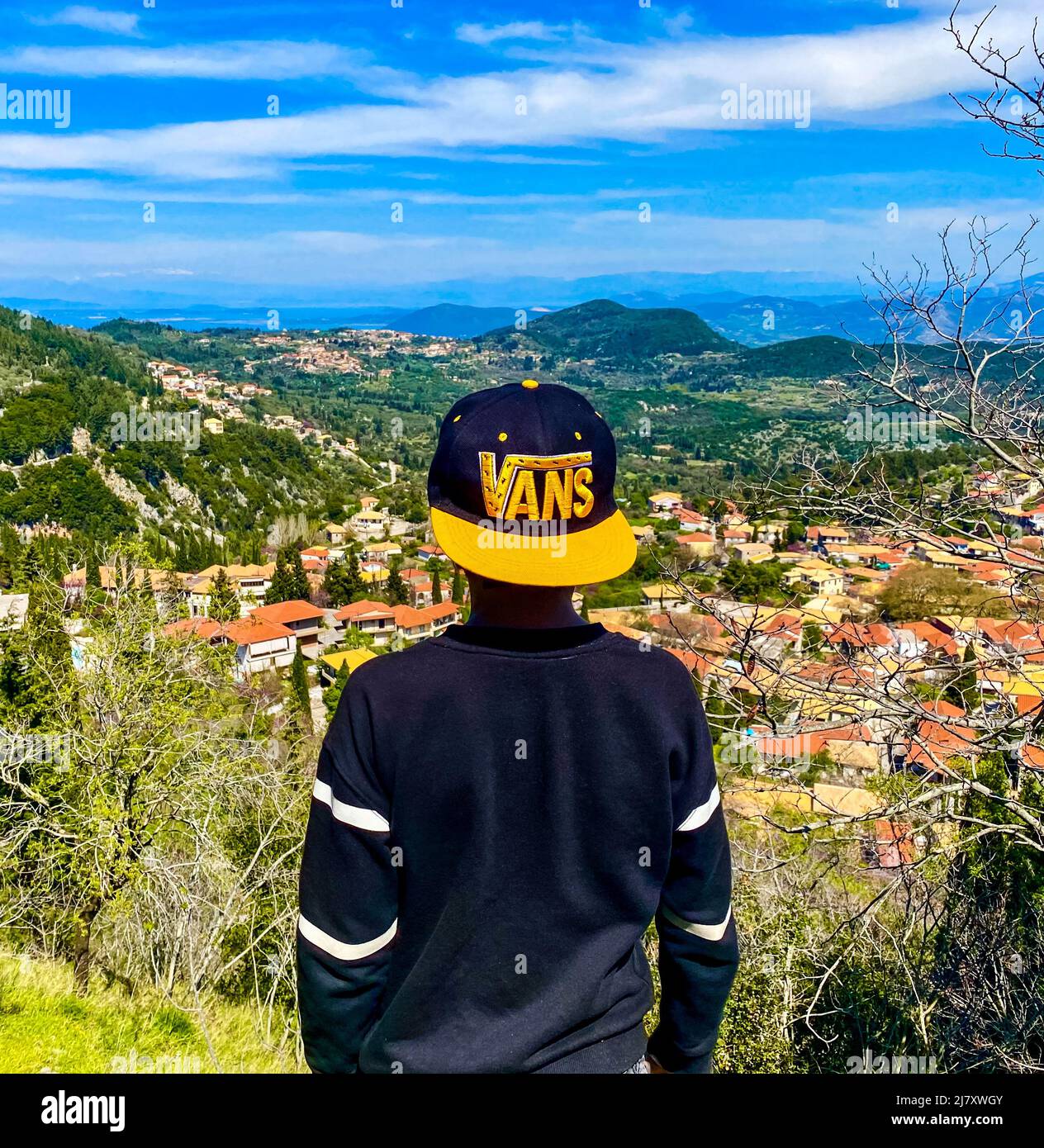 A young boy stares to a distant village in Greece Stock Photo