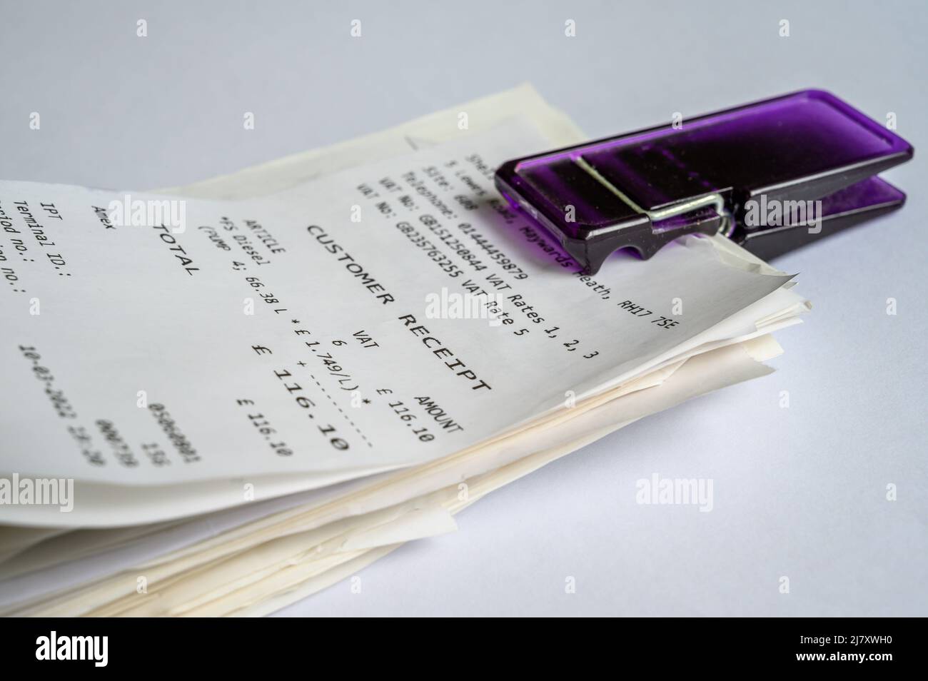 Closeup of a pile of credit and debit card receipts held together by a clip. Stock Photo