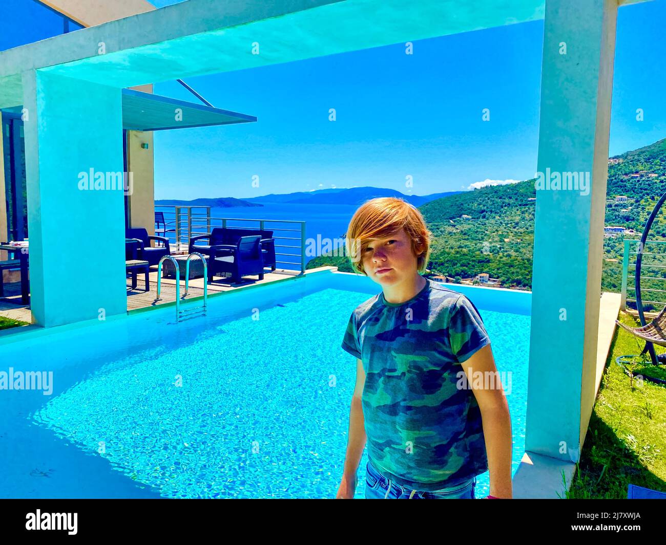 A you boy with red hair by a swimming pool, Greece Stock Photo