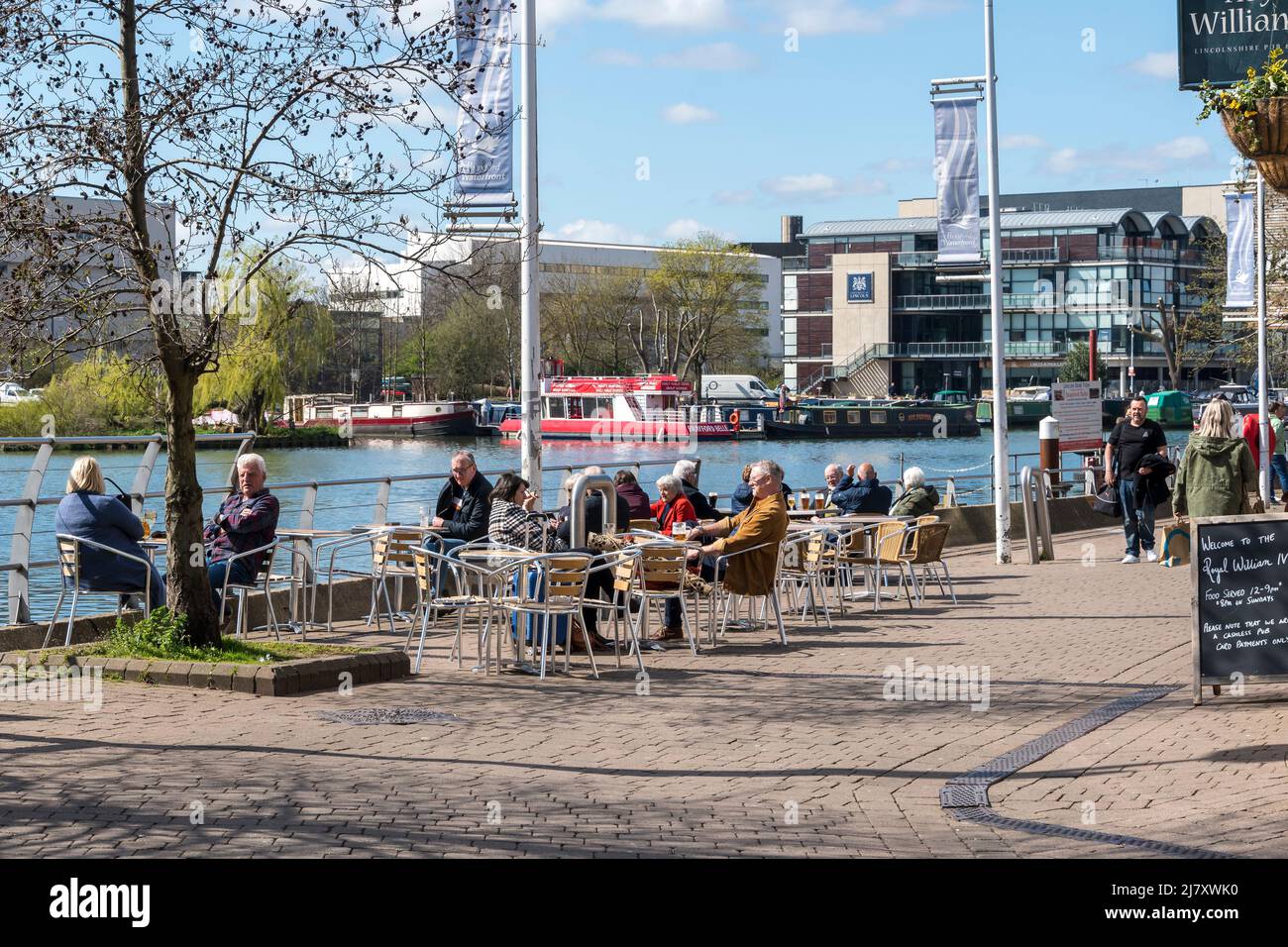 Royal William IV customers enjoying sun at side of Brayford pool Lincoln city 2022 Stock Photo