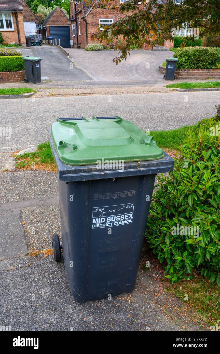 Green bins in residential road ready for collection. Stock Photo