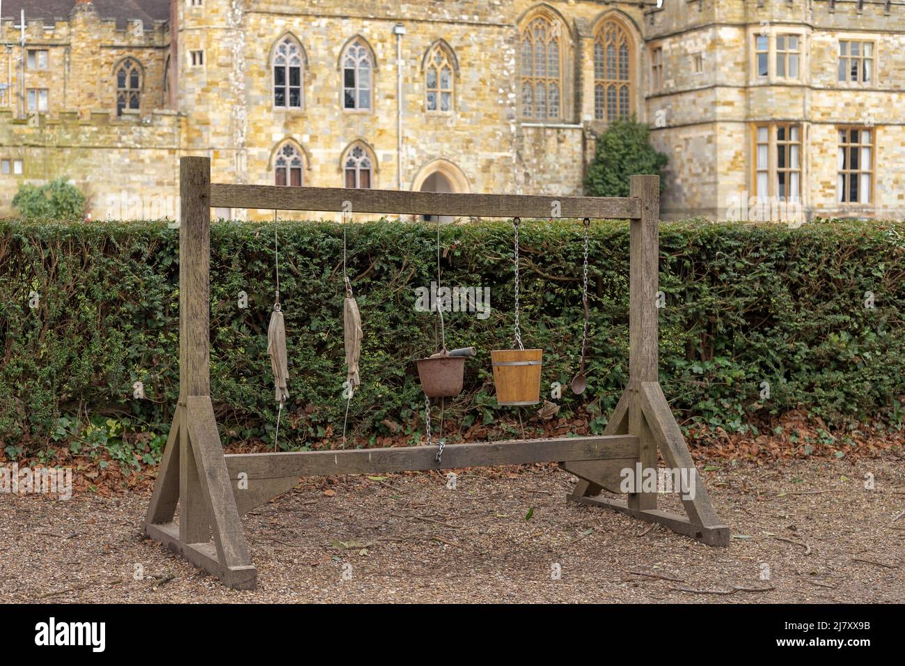 Gallows type wooden frame with various wooden items including a bucket