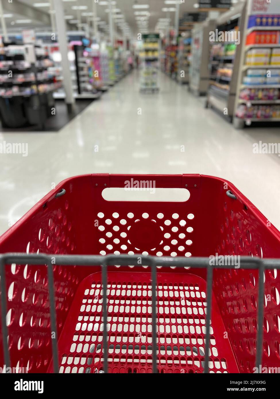 Red grocery shopping cart in the blurred aisles of a Target store. Stock Photo