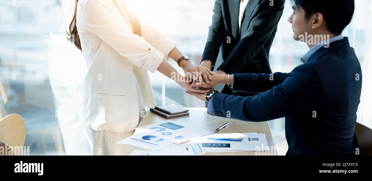Group of Asian team creative business people join hands partnership teamwork concept Stock Photo
