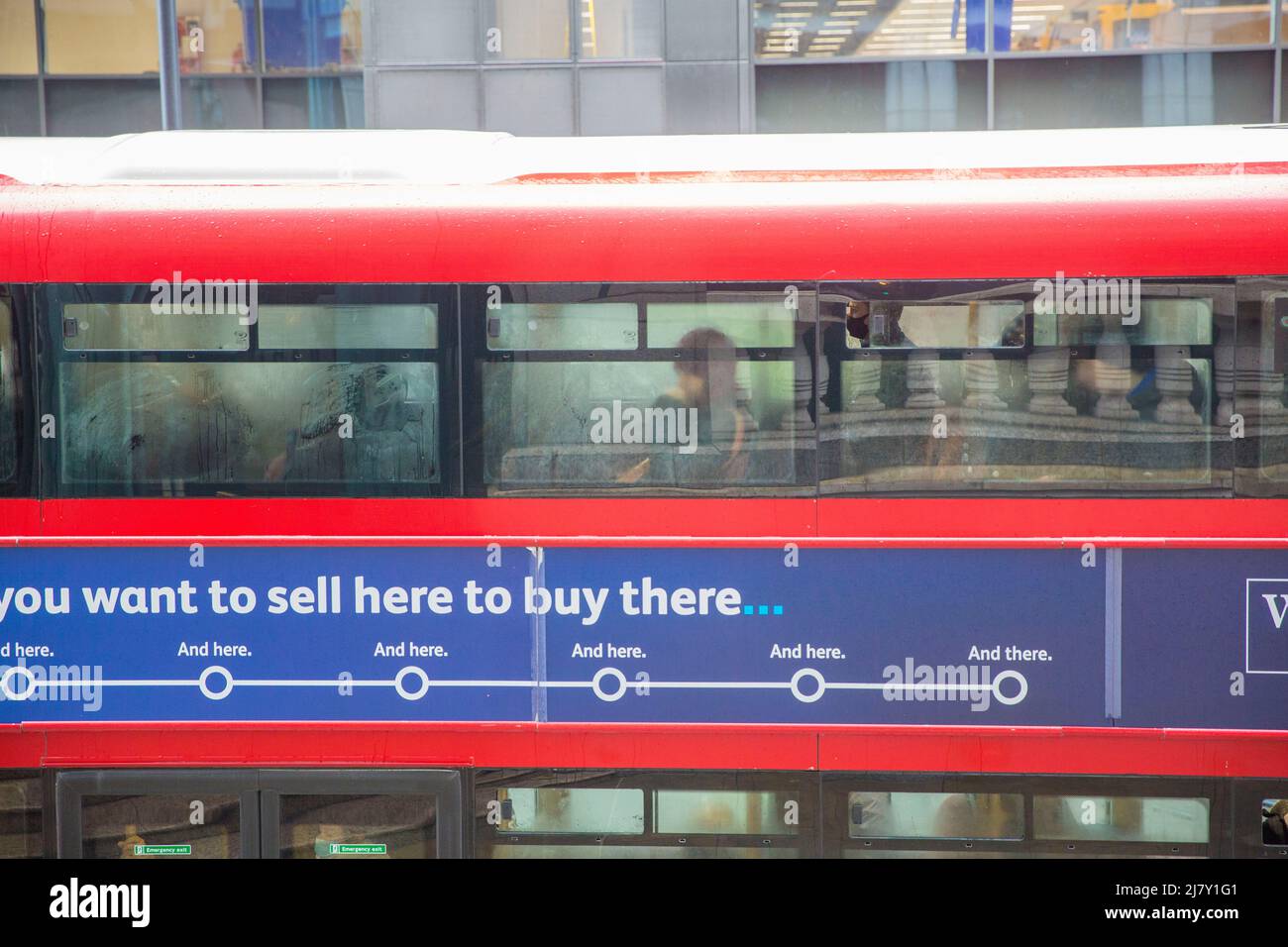 Passengers, some wearing a mask and others not, are seen in a double-decker bus in the City of London. Stock Photo