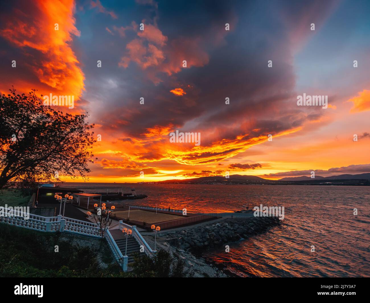 Bright dramatic sunset sky with fluffy clouds over sea resort, summer ...