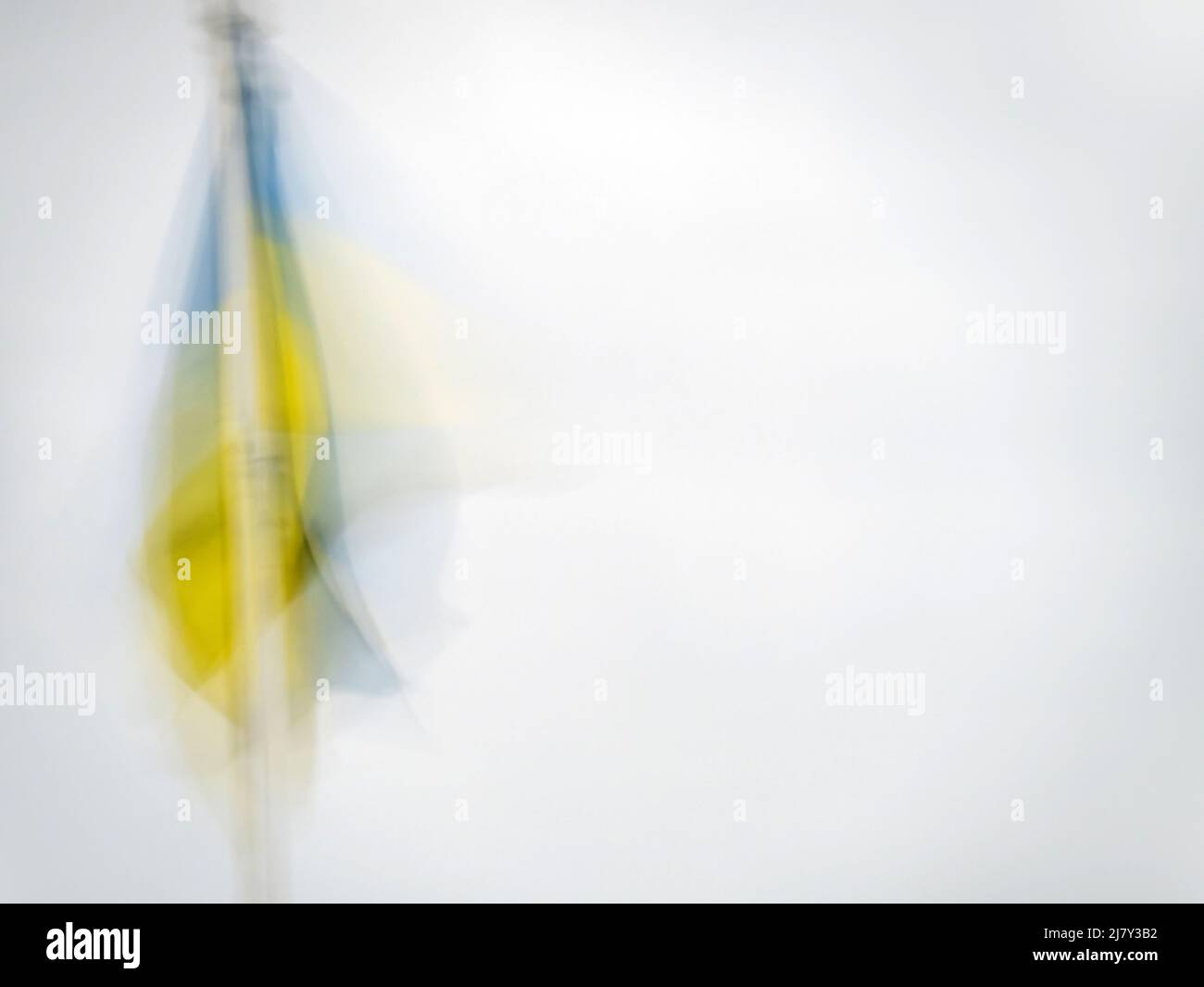 Ukraine national flag hanging in light breeze. Impressionist effect with copyspace. Stock Photo