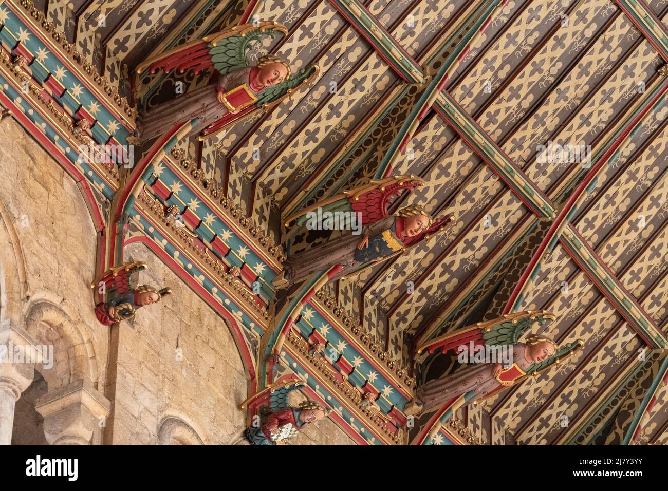 Colourful wooden angels look down from the painted ceiling of the North Transept of Ely Cathedral Stock Photo