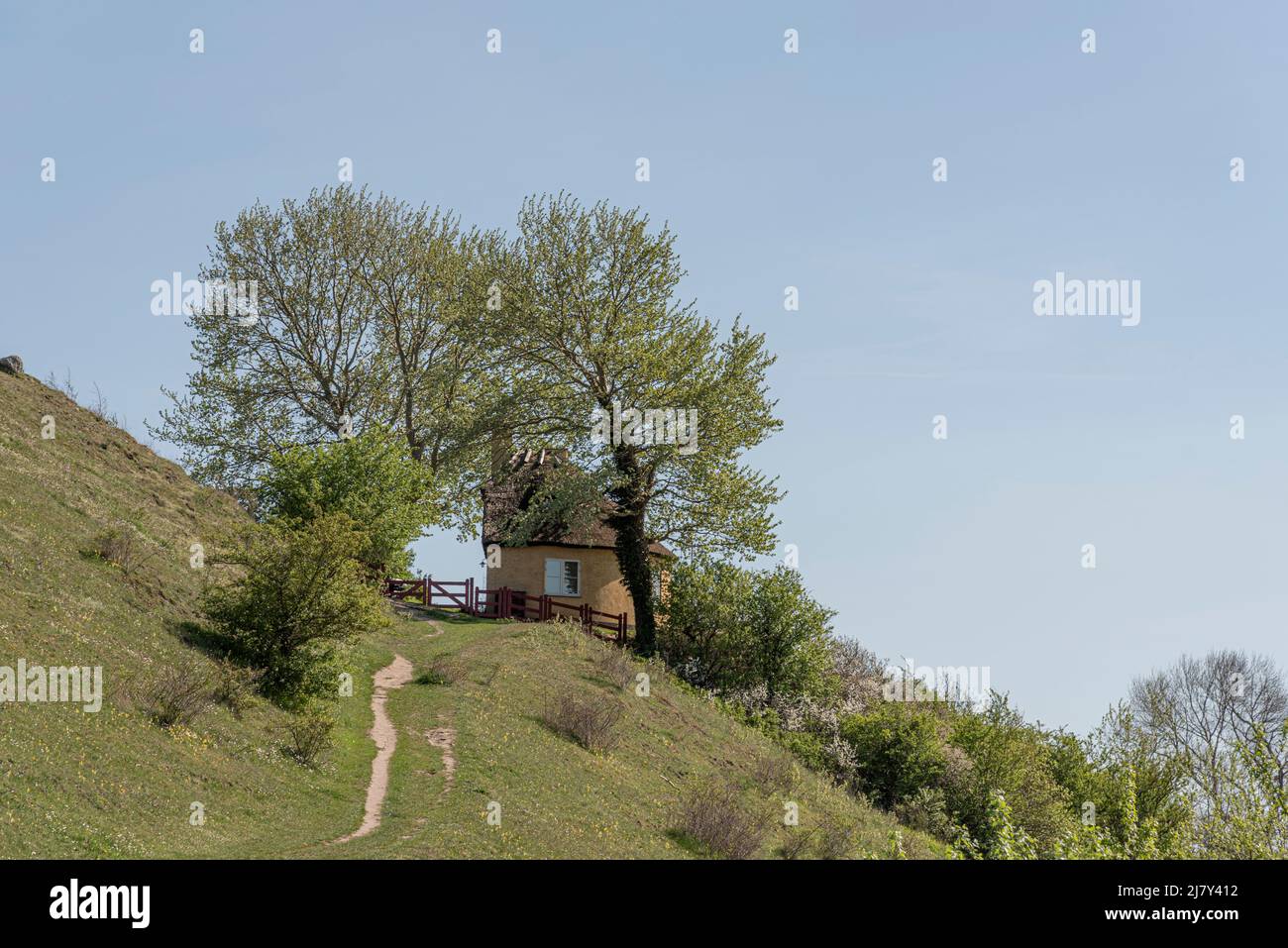 a little detatched cottage among the trees on a steep slope, Ejby, Denmark, May 9, 2022 Stock Photo