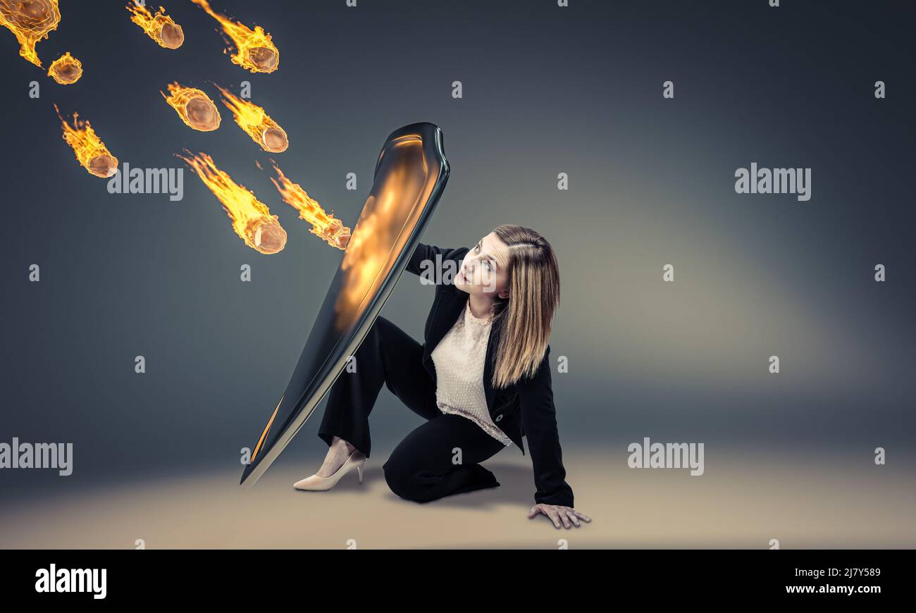 woman protects herself with a shield from a rain of fiery rocks Stock Photo
