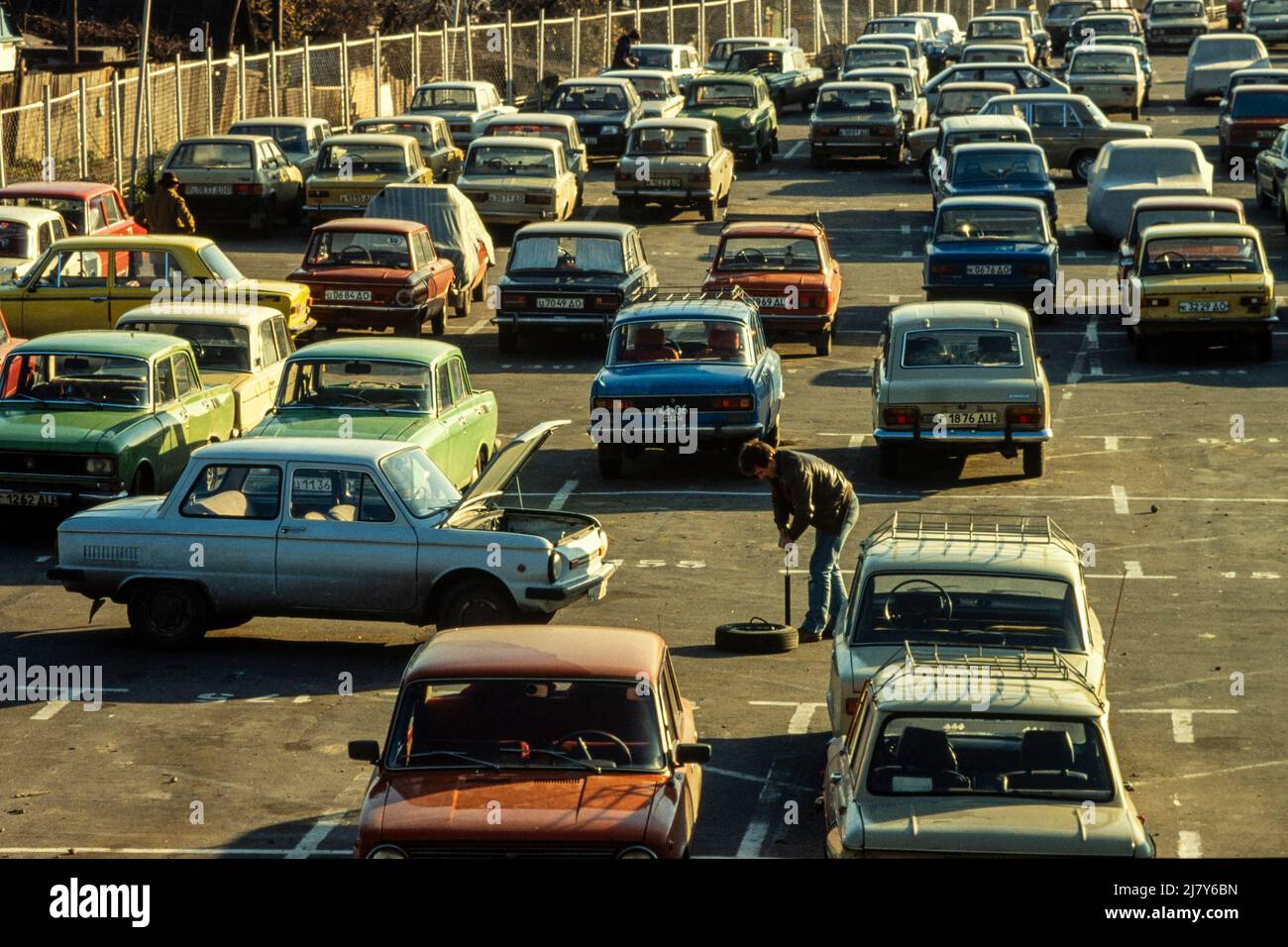 Pumping up a flat tyre by hand in a car park, Kiev. October 1989 Stock Photo