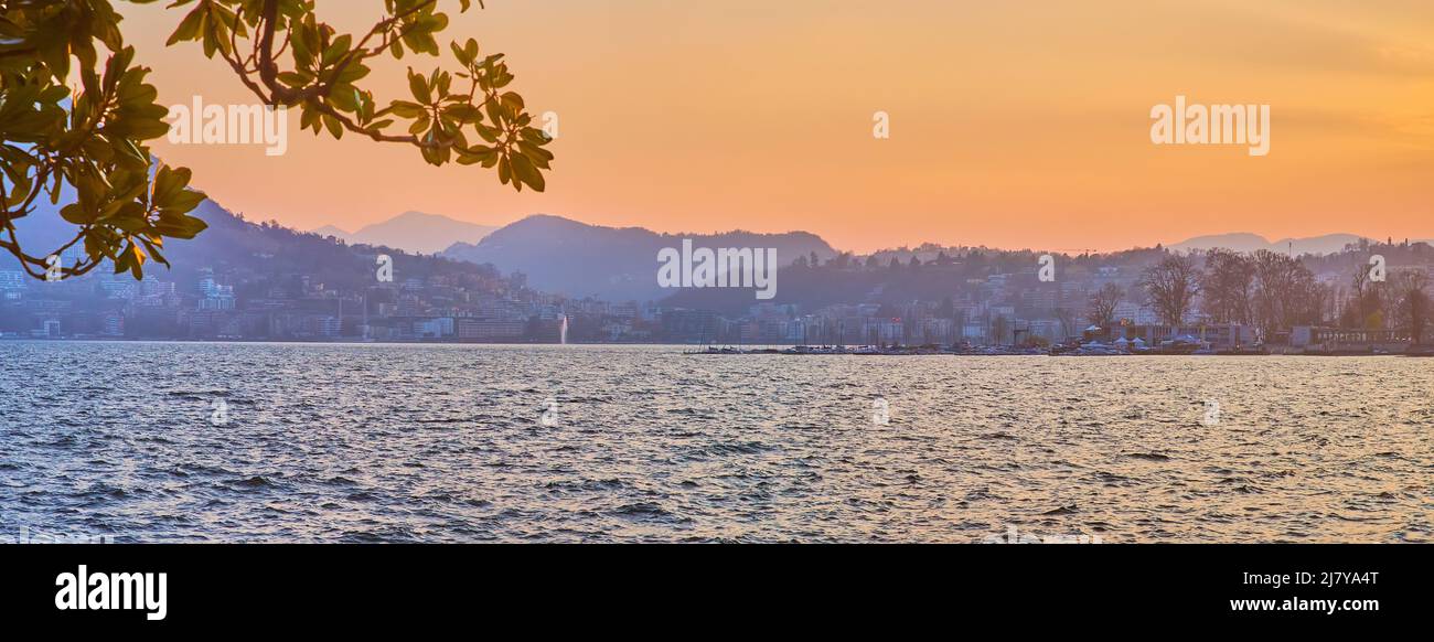 The view on the Lugano Lake and mountains on background during twilights, Lugano, Switzerland Stock Photo