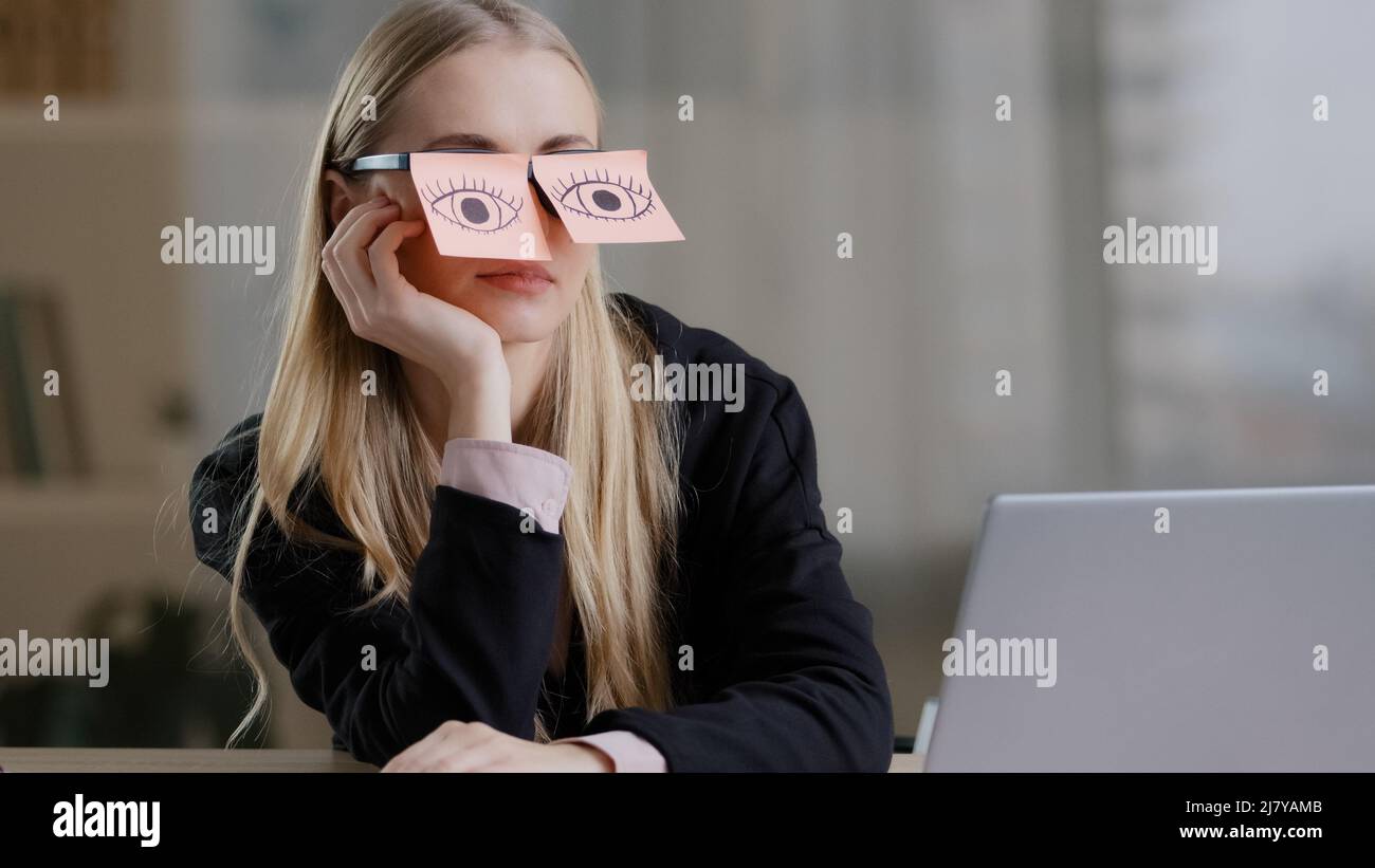 Tired sleepy caucasian woman with adhesive notes on eyes sticky notes