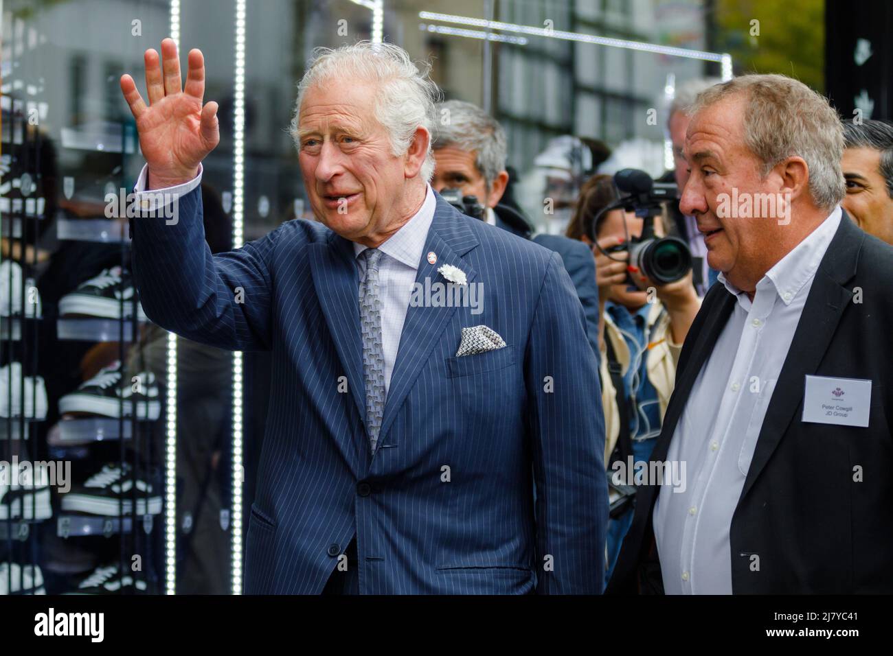 Walworth, London, UK. 11th May 2022,HRH Prince Charles, The Prince of Wales, Founder and President of The Prince’s Trust, beside Peter Cowhill of the JD Group, waves to wellwishers  during his visit to The Prince’s Trust Kickstart supported young peopleat JD Sports. Amanda Rose/Alamy Live News Stock Photo