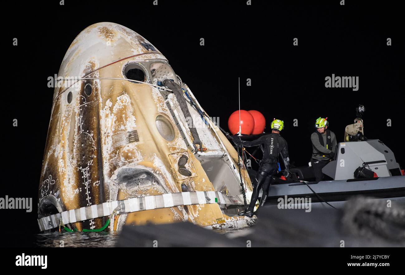 The SpaceX Crew Dragon Endurance spacecraft is secured by divers before being lifted onboard the SpaceX Shannon recovery ship after splashdown in the Gulf of Mexico May 6, 2022 off the coast of Tampa, Florida.  The capsule carried NASA SpaceX Crew-4 astronauts Raja Chari, Kayla Barron, Tom Marshburn, and ESA astronaut Matthias Maurer back to earth from 177-days aboard the International Space Station. Stock Photo