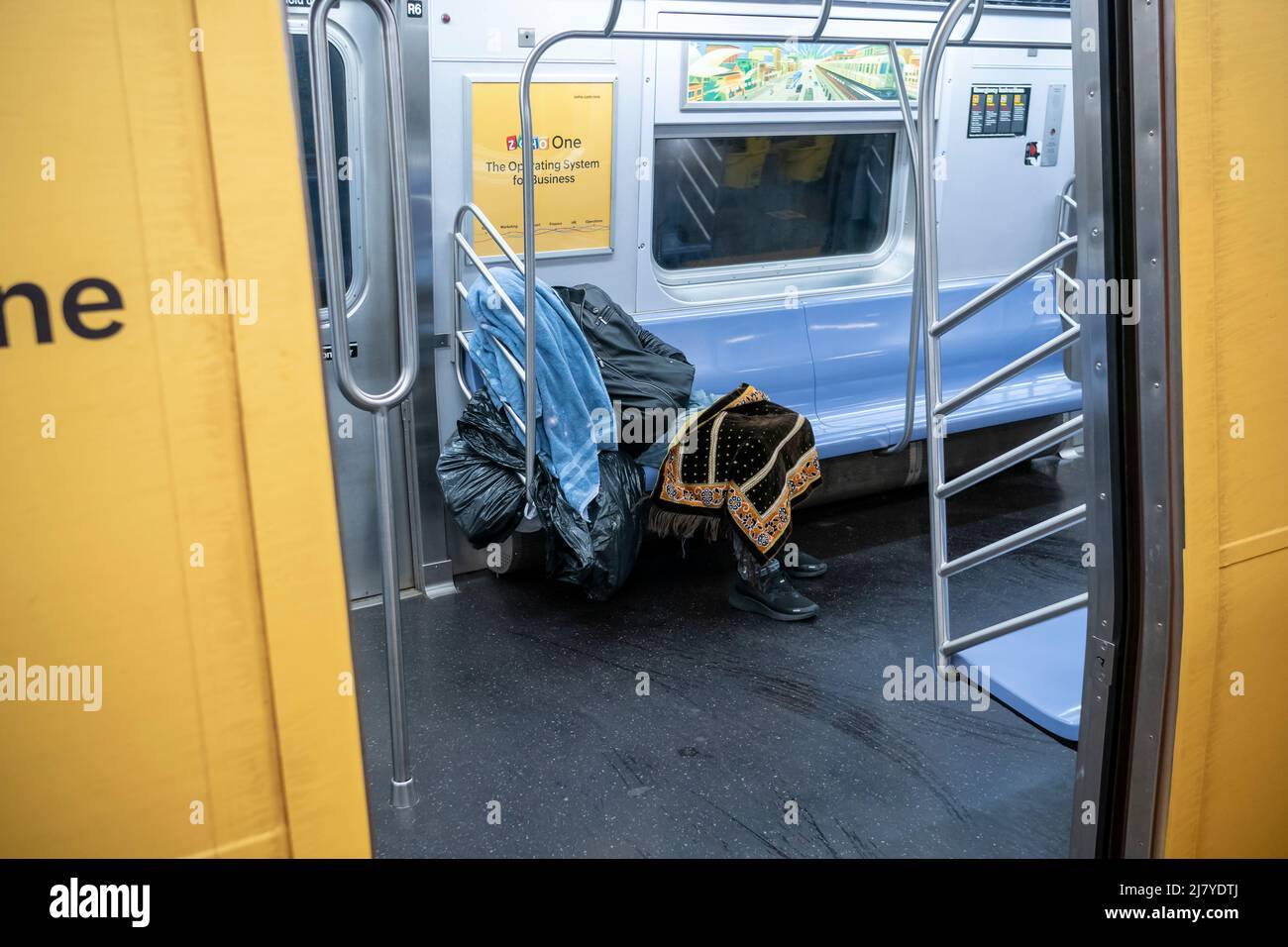 A homeless man sleeps on an E line subway train in New York on Saturday ...