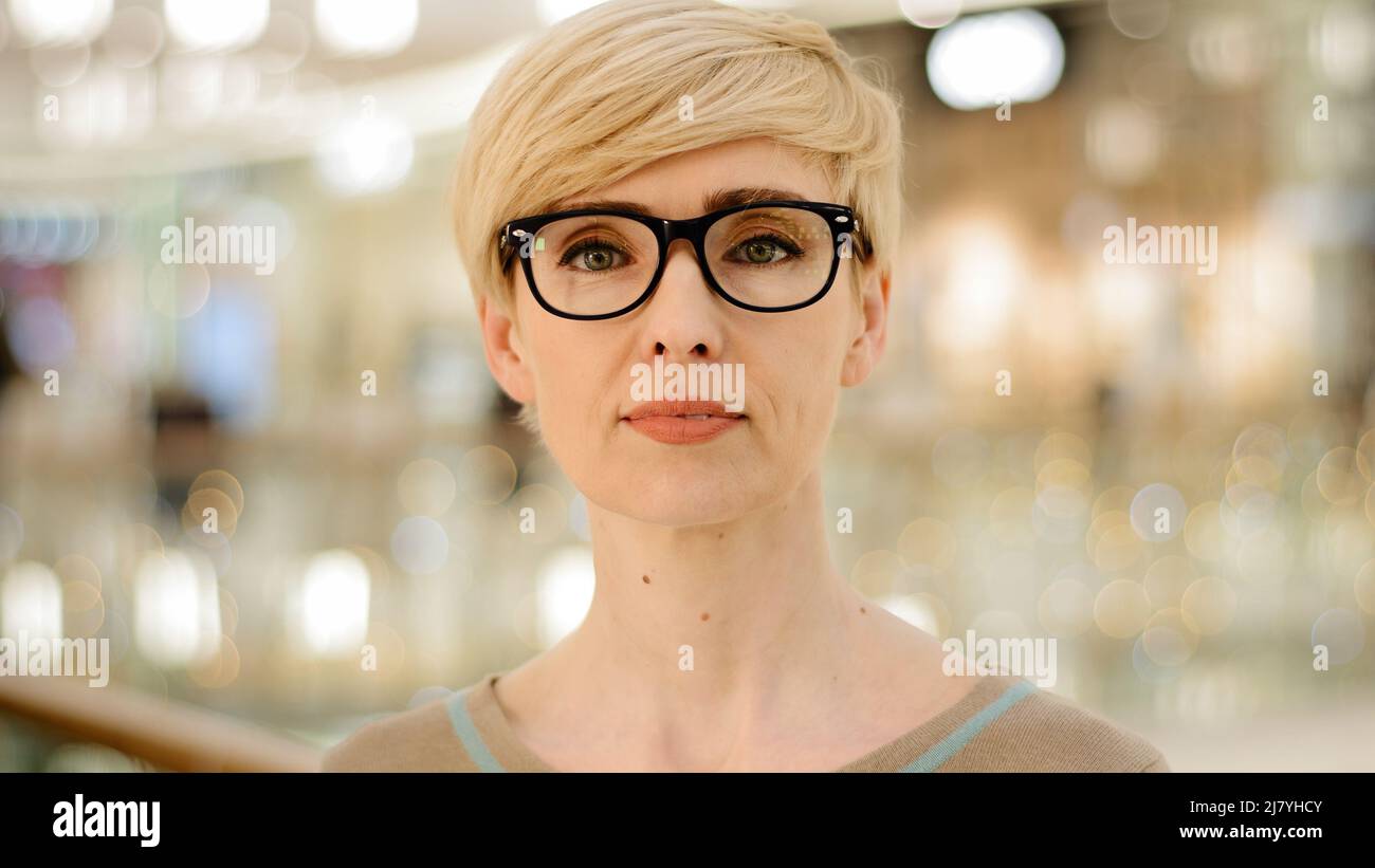 Close-up middle-aged adult lady in glasses looking at camera poor vision problems with eyesight. Portrait caucasian business woman female specialist Stock Photo