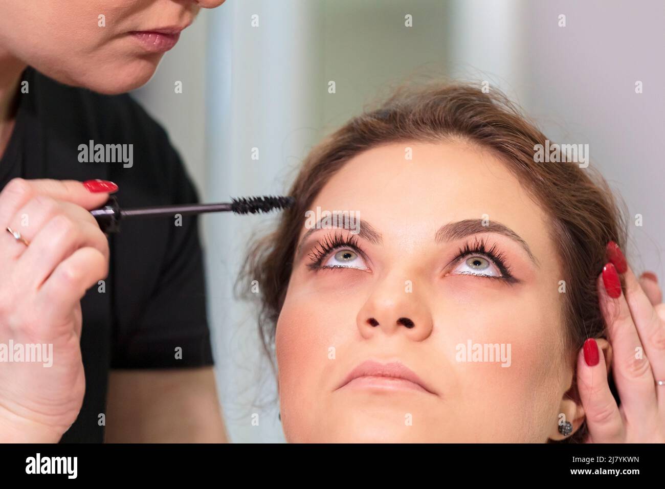 Master stylist makes makeup for eyelashes to a girl in a beauty salon. Russia Moscow August 20, 2020. Stock Photo