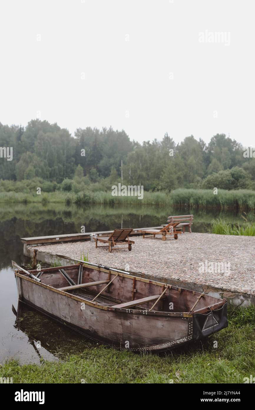 wooden boat by the pier on the lake Stock Photo - Alamy
