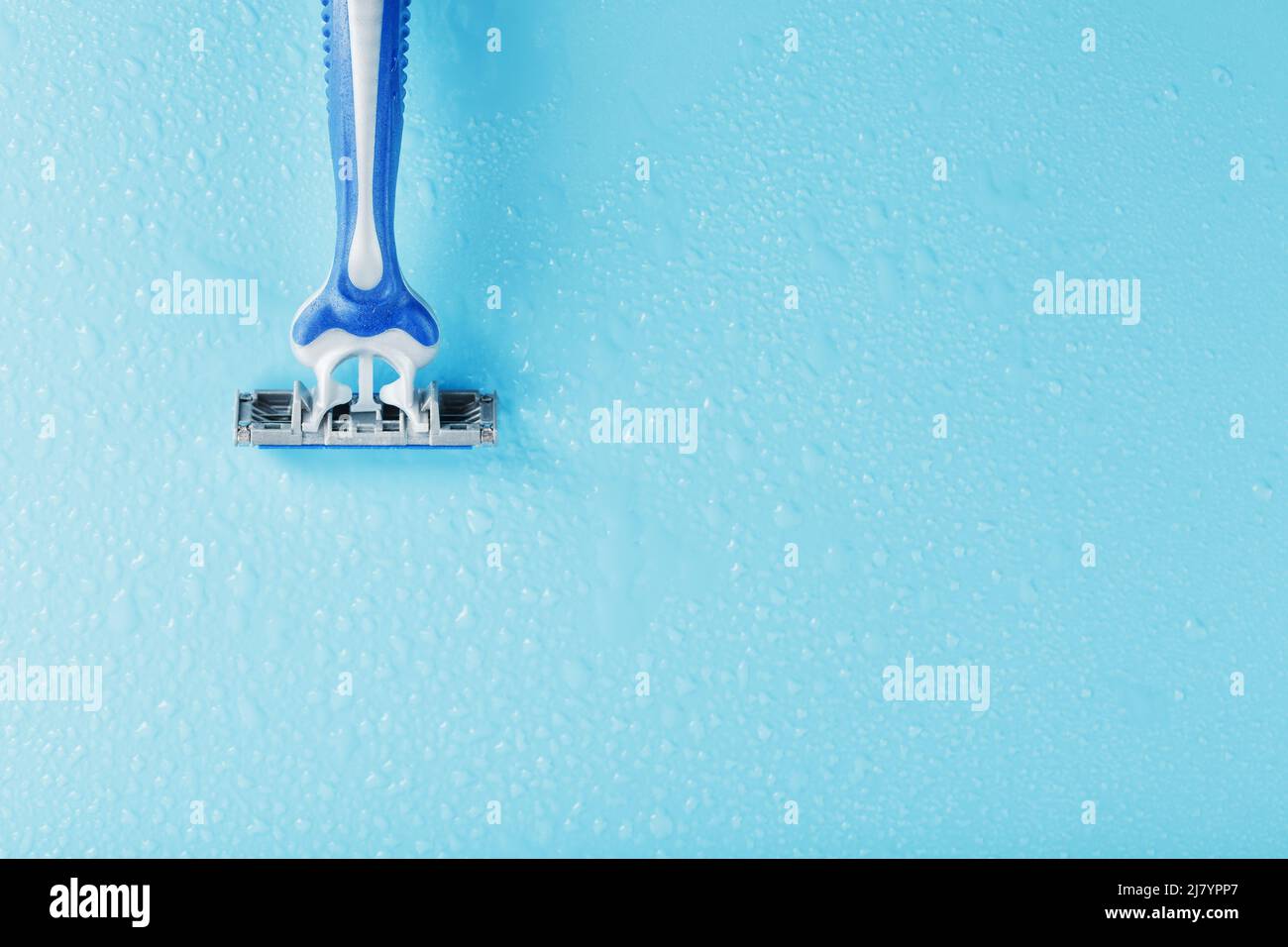 Razor blades on a blue background with drops of icy water close-up free space. The concept of purity and freshness Stock Photo