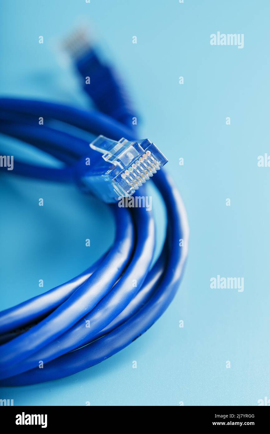 Blue UTP Internet Cable - Isolated on a blue background Ethernet Cord Stock Photo
