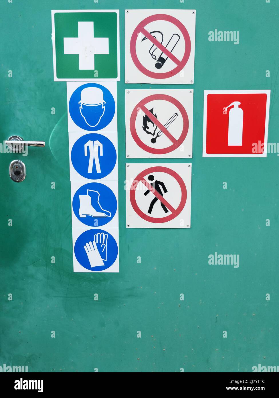 Safety signs on a green door for warning and safety Stock Photo Alamy