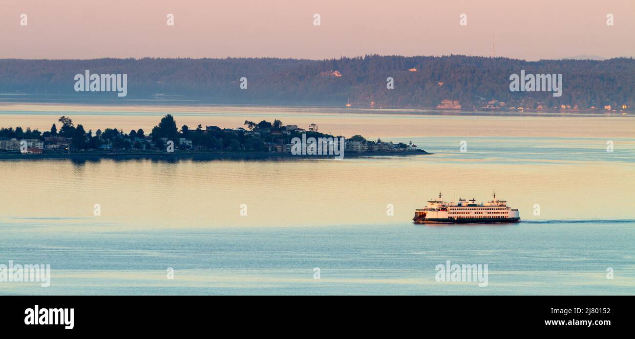 Washington State Ferry passing Alki Point during sunrise at Elliot Bay - Seattle - Washington - USA Stock Photo
