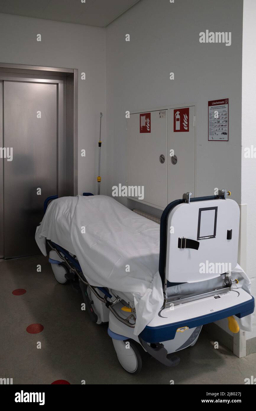 a patient transport bed stands in front of an elevator in a hospital