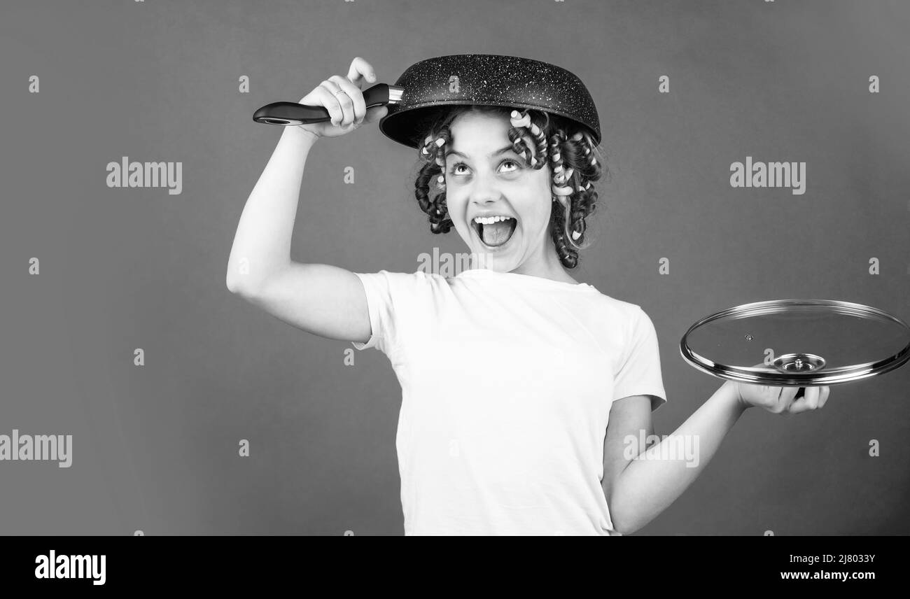 Culinary and house duties. Healthy food. Perfect for pancakes. Small girl with curlers in hair. Pin up style. Girl hold Frying Pan. Little kid hold Stock Photo