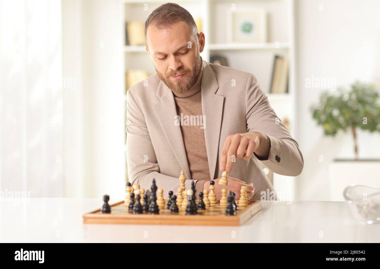 Young man playing chess alone at home Stock Photo Alamy