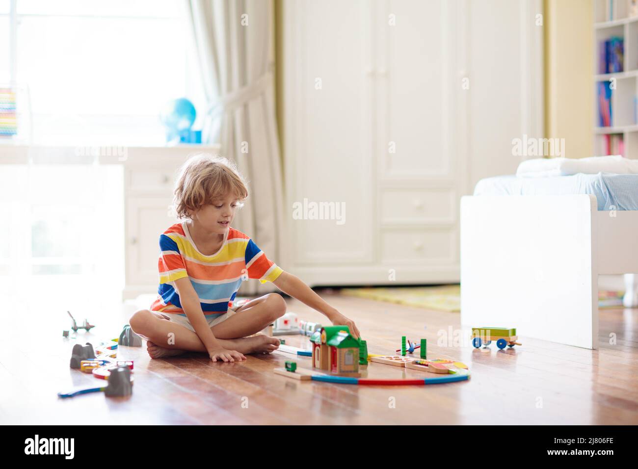 Kids play with wooden railway. Child with toy train. Educational toys