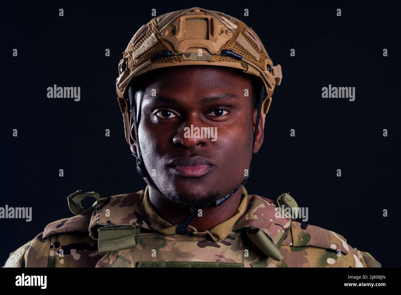 military army african male warrior camouflage suit sorrow sadness wrapped in an American flag black background studio, lying violence news criminal Stock Photo