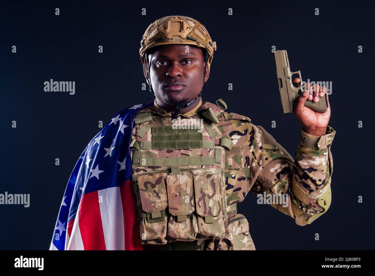 military army african male warrior camouflage suit sorrow sadness wrapped in an American flag black background studio, lying violence news criminal Stock Photo