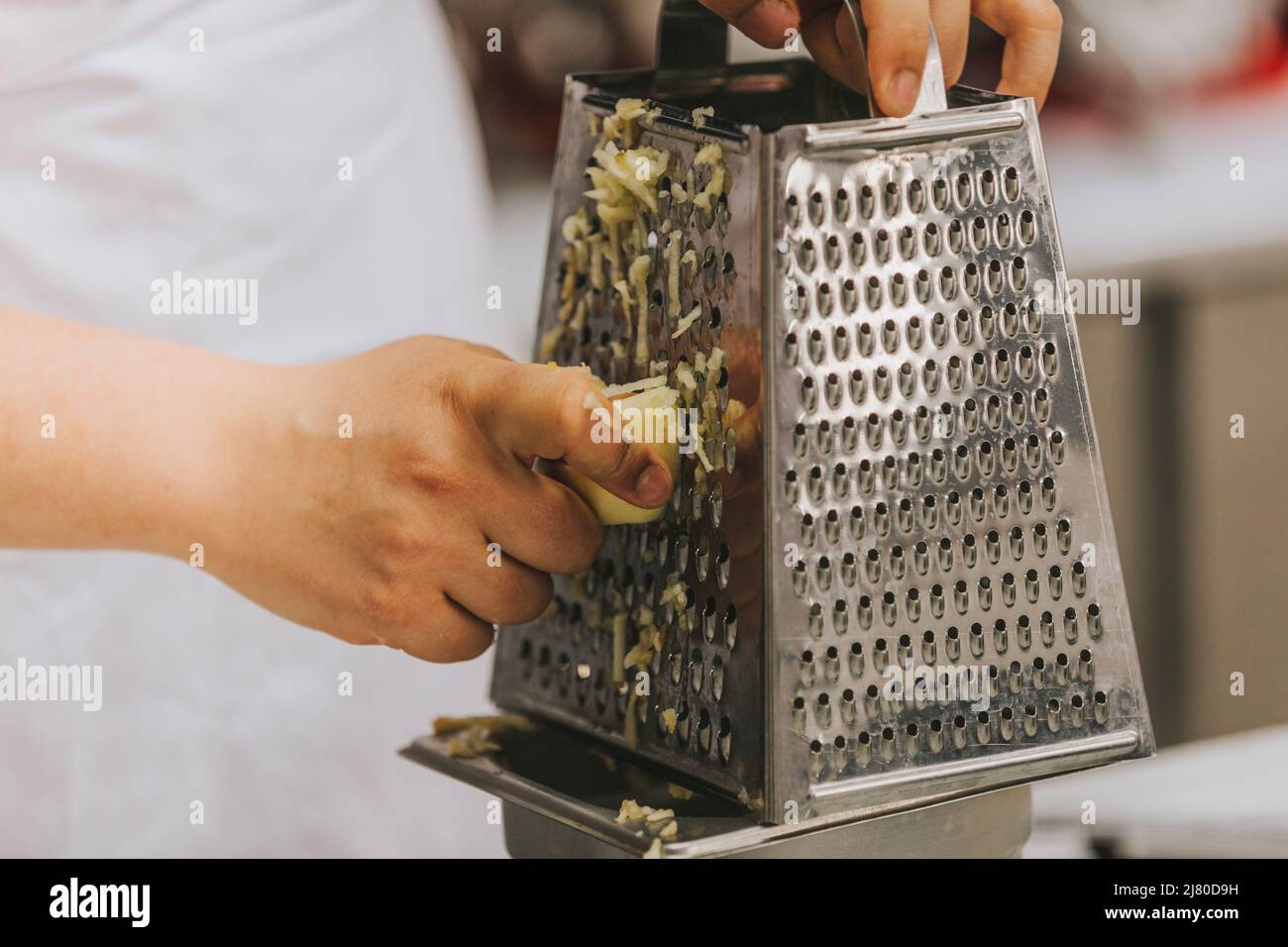 Cook's hand grating apples for apple pie Stock Photo