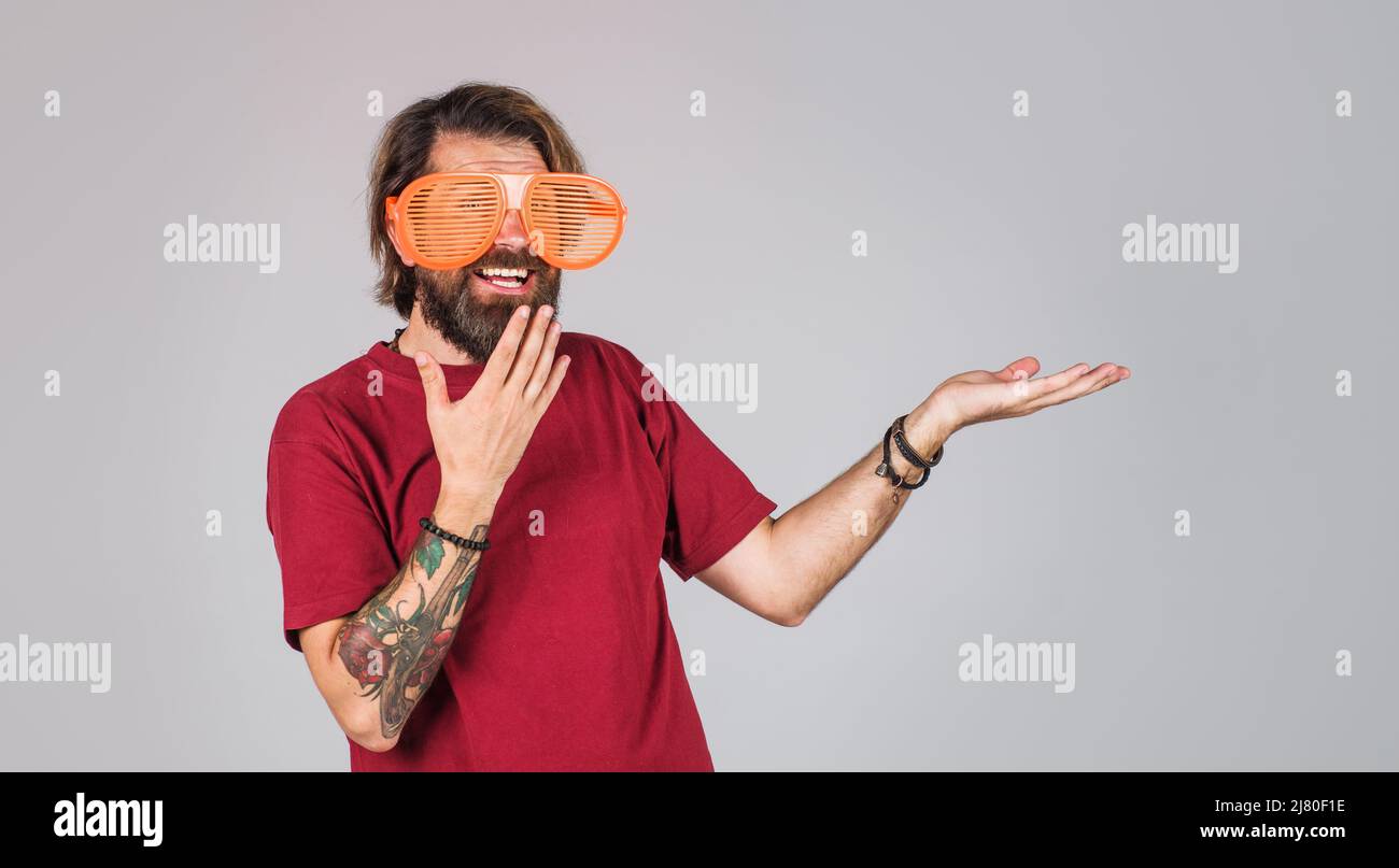 Surprised man in funny big glasses presenting product hold something on palm. Season Sale, discount. Stock Photo