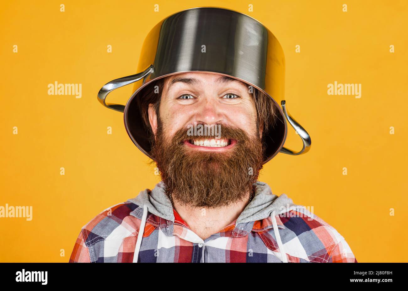 Kitchenware. Cooking utensil for food preparation. Kitchen cookware. Crazy chef with pot on head. Stock Photo