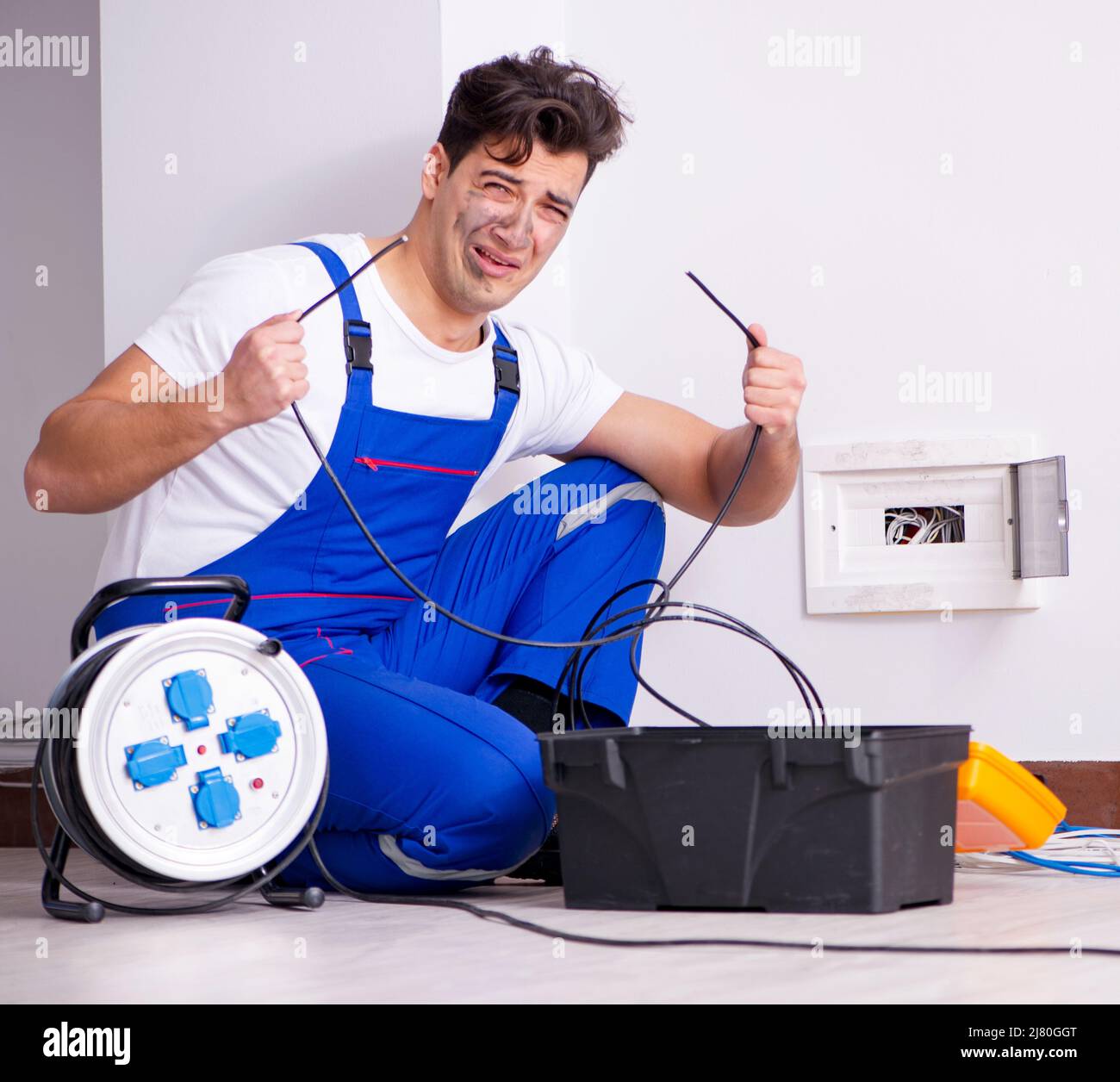 The funny man doing electrical repairs at home Stock Photo