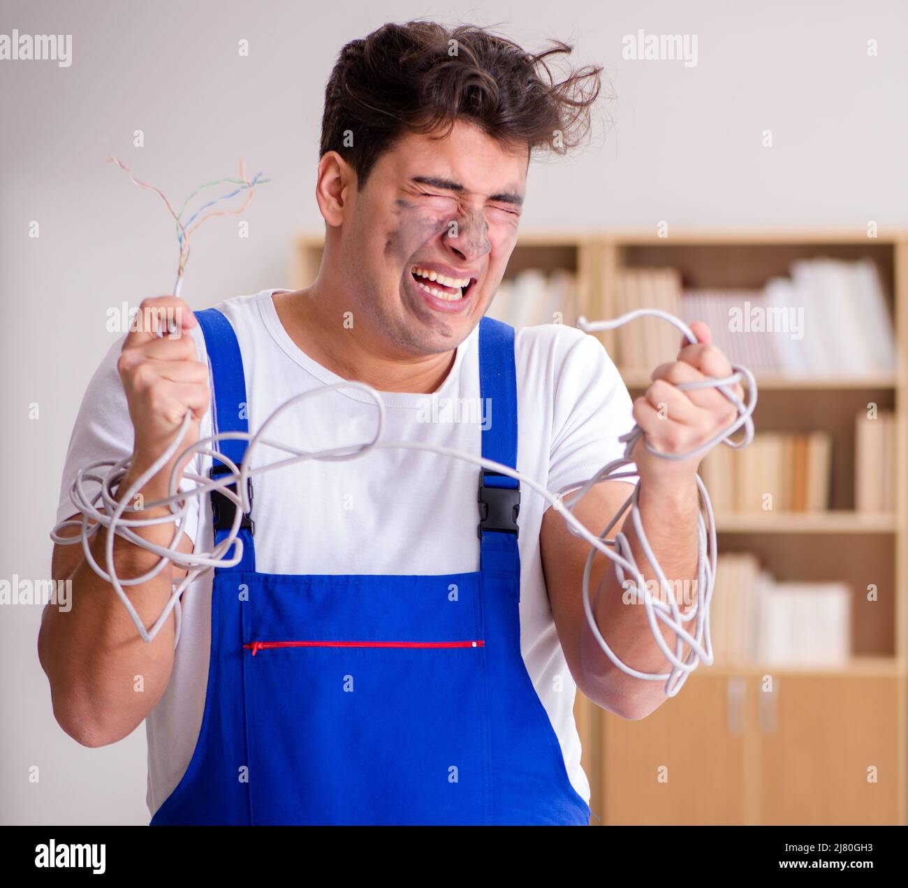 The funny man doing electrical repairs at home Stock Photo