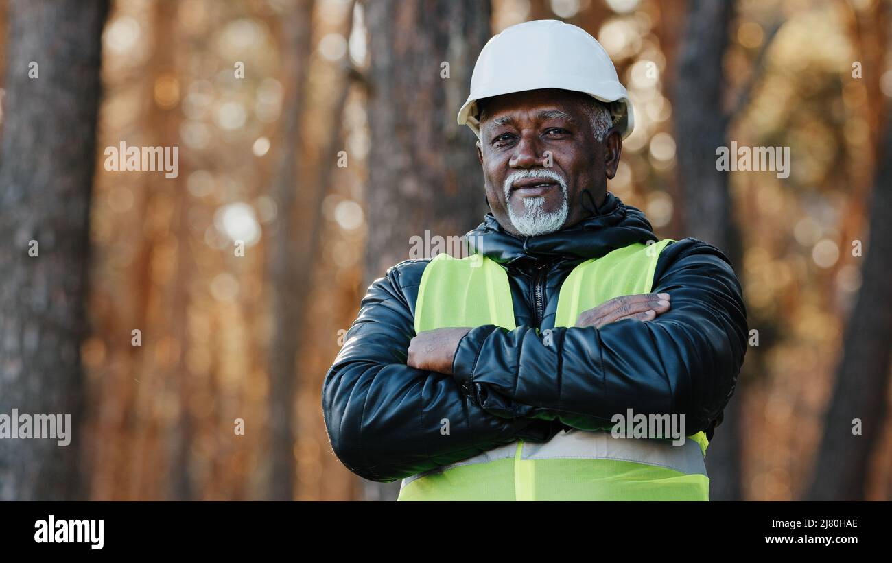 Mature african american confident male businessman standing outdoors professional forestry engineer foreman worker forester in uniform in protective Stock Photo