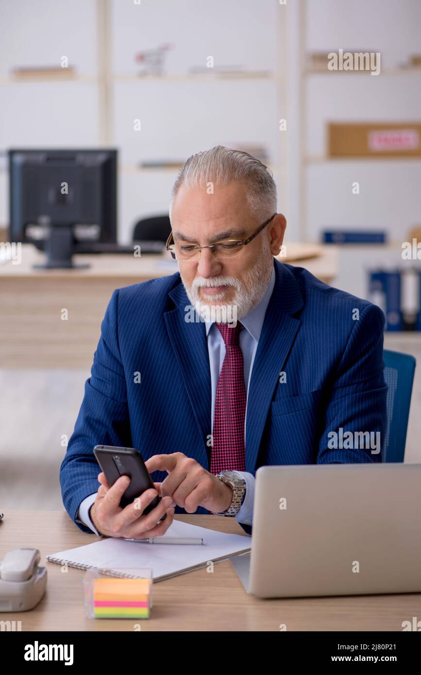 Old businessman employee working at workplace Stock Photo - Alamy