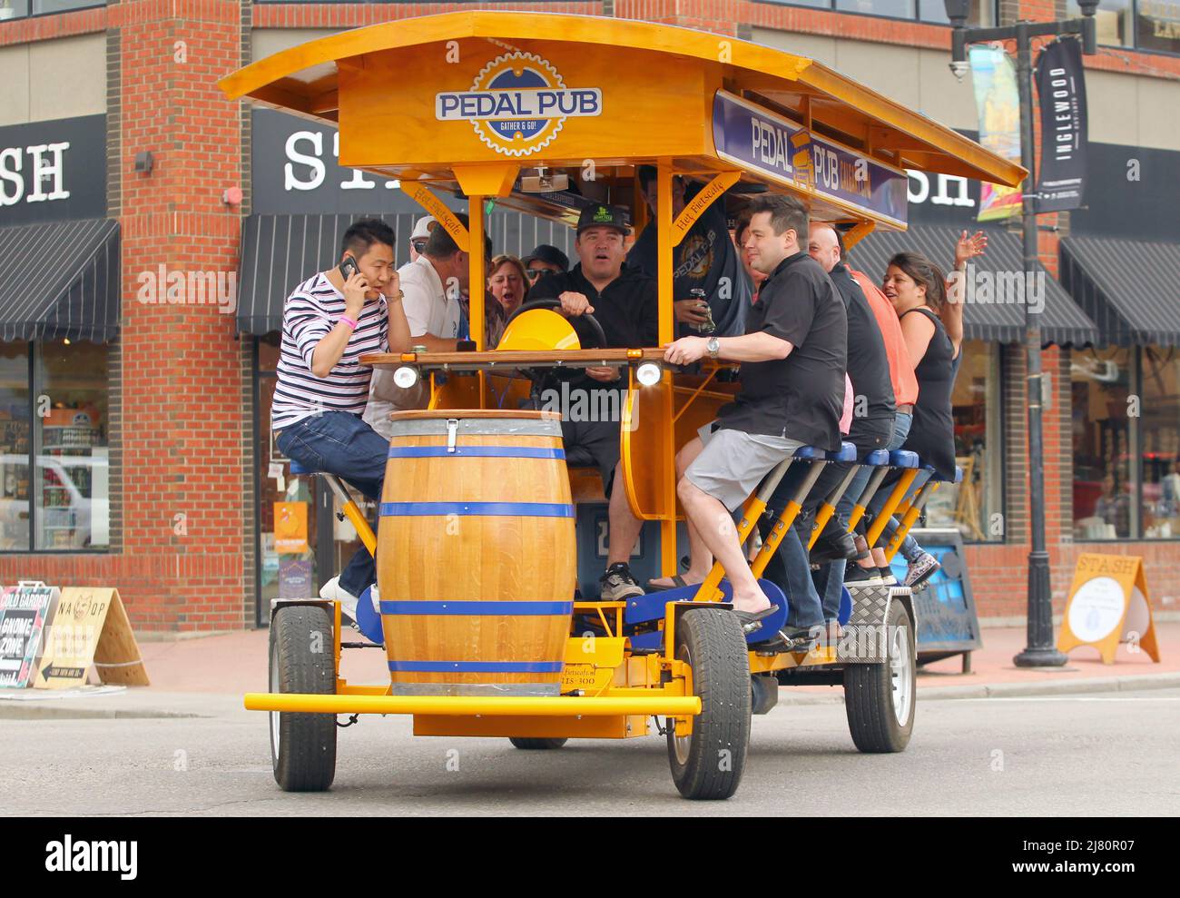 People enjoy a drink on a Pedal Pub, a mobile bar powered by it's patrons in Inglewood in Calgary, Alberta Canada. Stock Photo