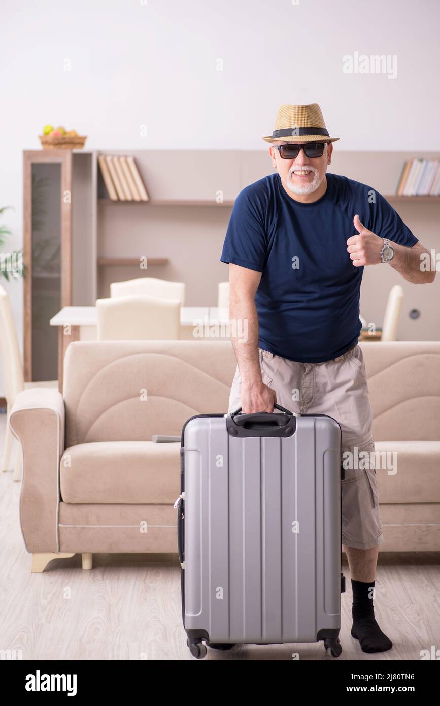 Old male tourist preparing for trip at home Stock Photo