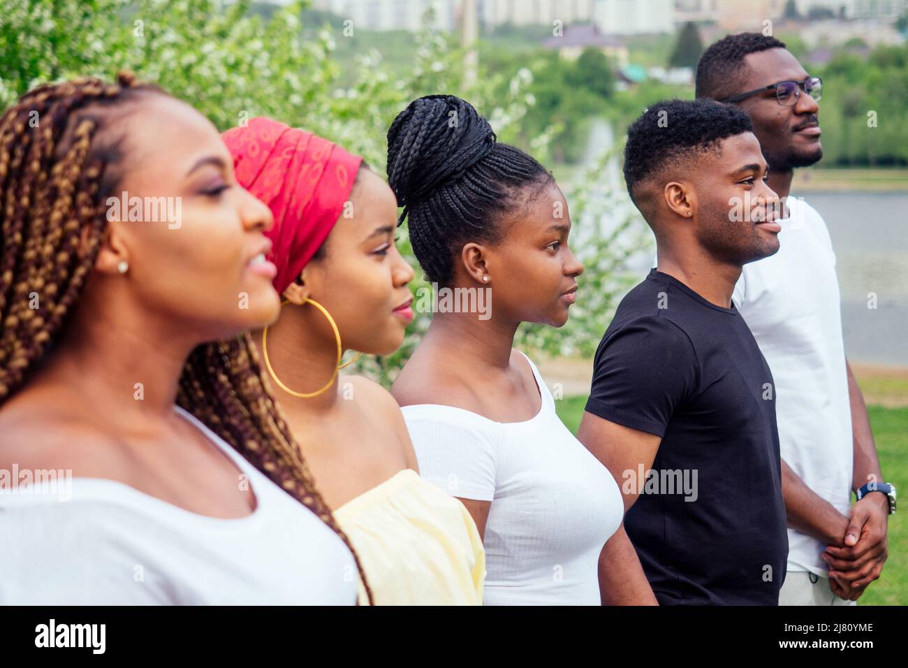 group of five smiling african-american men and women walking outside cloudy weather near the lake,exchange students in Russia Stock Photo