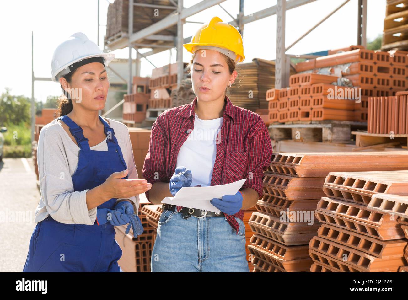 Female workers having conversation in outdoot warehouse Stock Photo