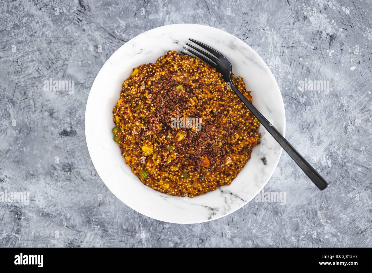vegan quinoa with corn peas and carrots wit red pesto and flaxseeds