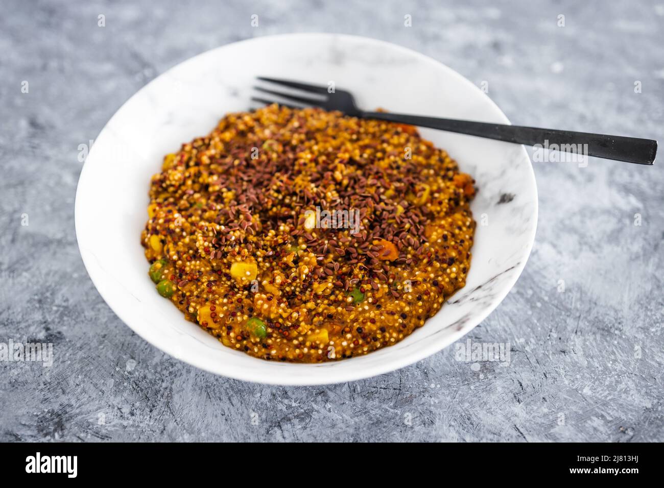 vegan quinoa with corn peas and carrots wit red pesto and flaxseeds