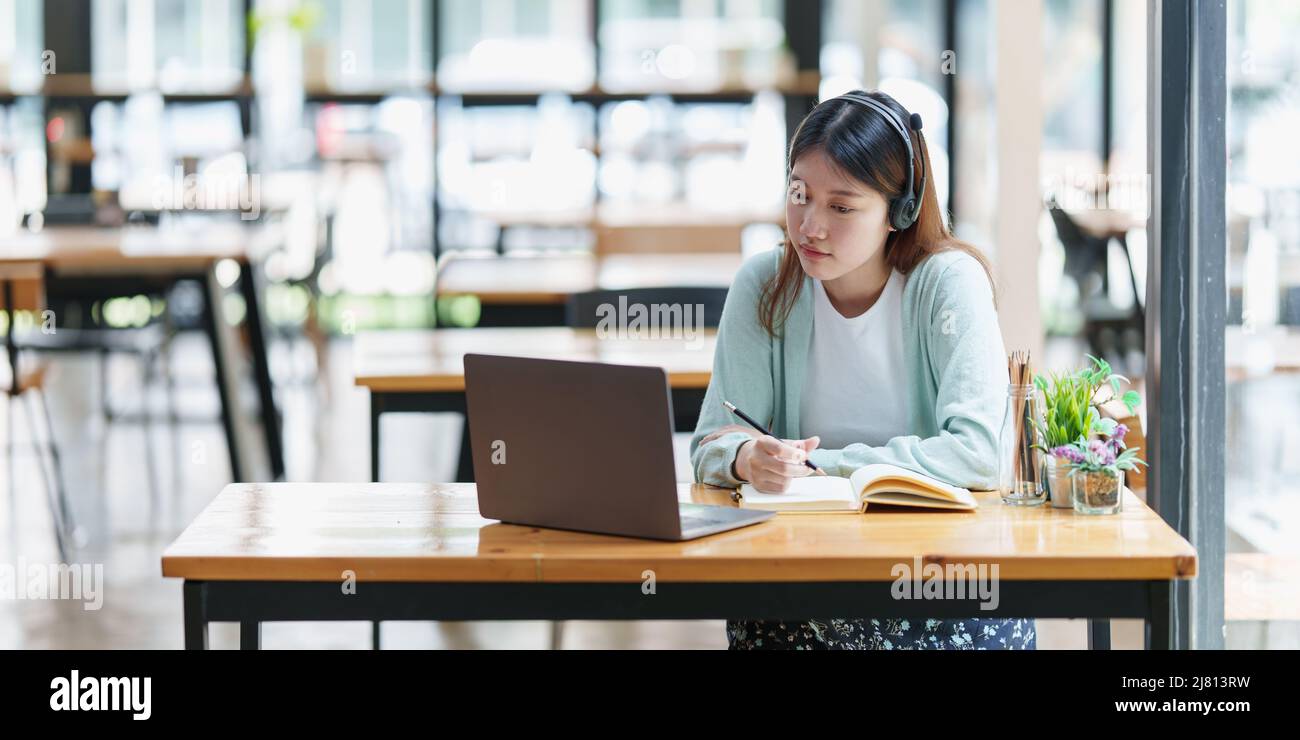 E-learning Online Education concept. Asian woman attentive student video conference e-learning with teacher on laptop computer at home. Stock Photo